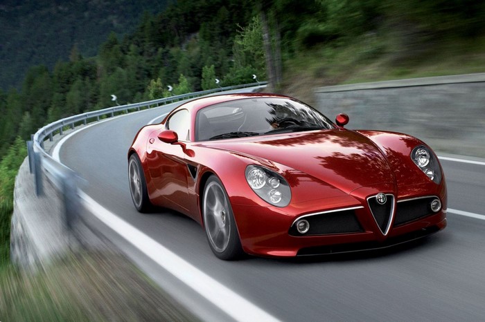 Red Alfa Romeo 8C Competizione driving on a winding road