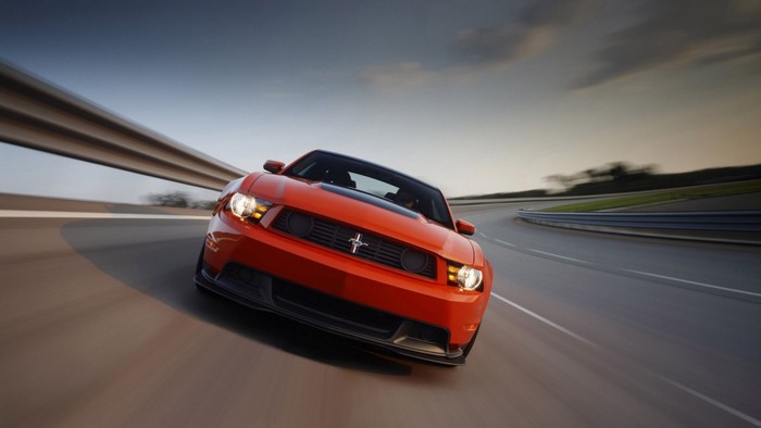 Orange Ford Mustang driving on a track