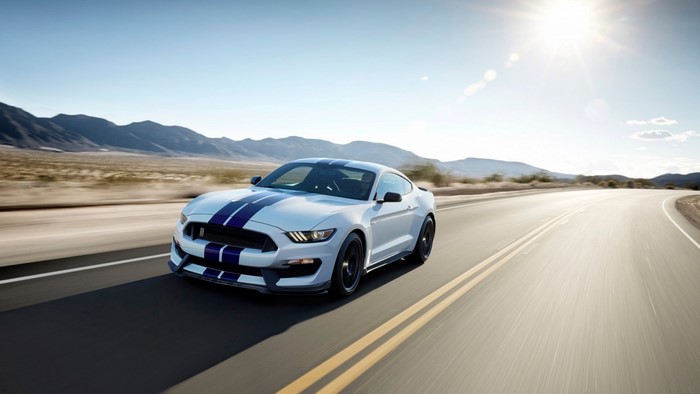White Ford Mustang Shelby GT350 driving on a desert road