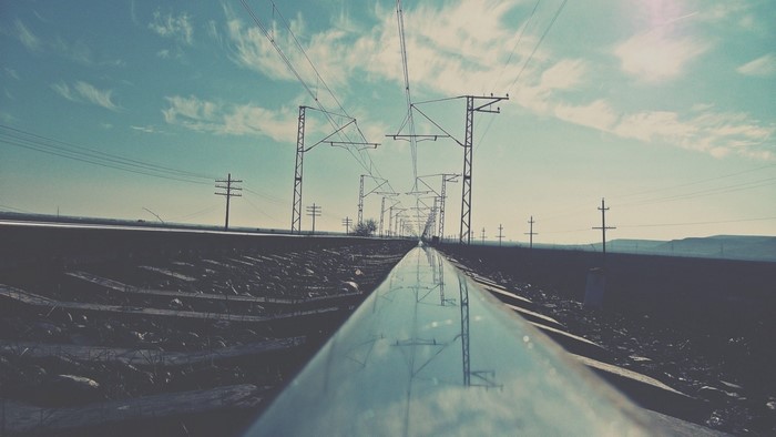 Railway tracks with overhead power lines and utility poles