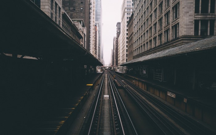 Train tracks between city buildings and platforms