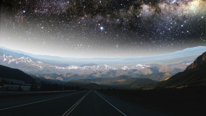 Road through mountains under a starry sky