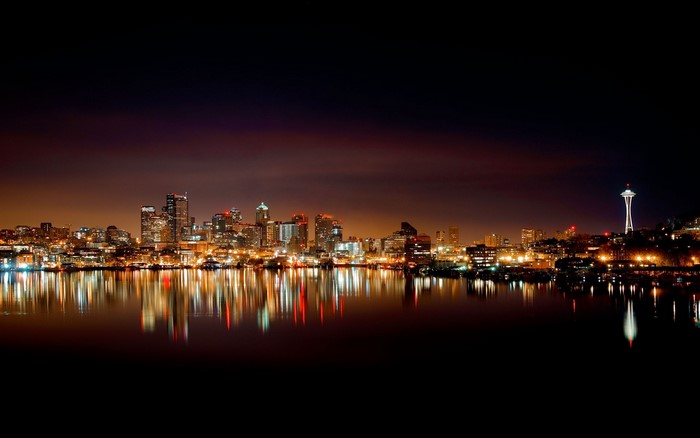 Seattle skyline at night with Space Needle and water reflection