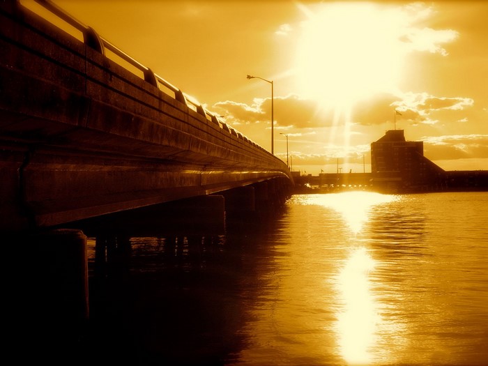 Bridge over water with sun and building
