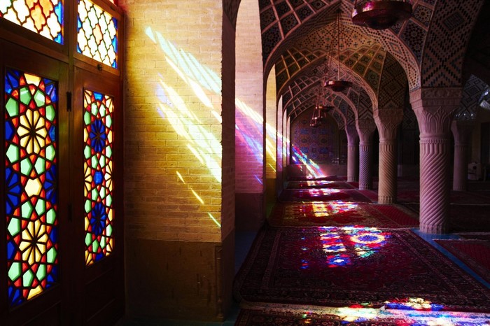 Mosque interior with stained glass windows and colorful light reflections
