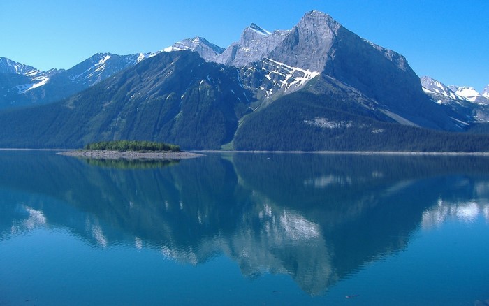 Mountains reflected in a calm lake with an island