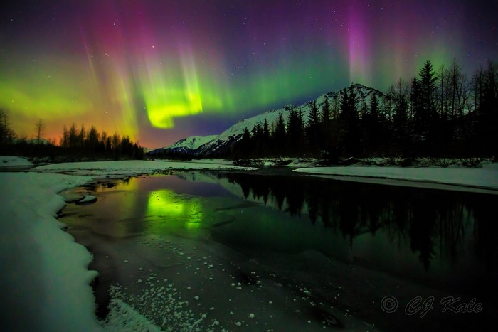 Aurora Borealis over snowy mountains and river