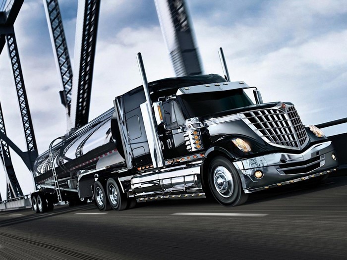 Black semi-truck with trailer on a bridge