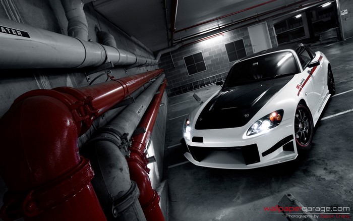 White Honda S2000 with black hood in garage
