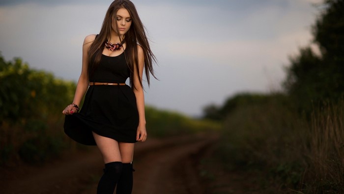 Woman in black dress posing outdoors