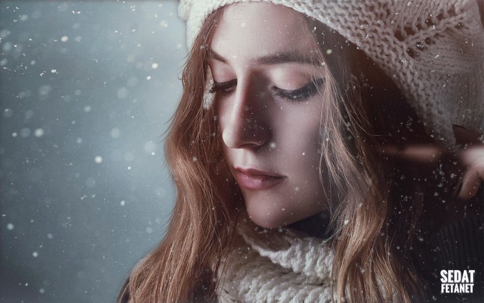 Woman in winter hat and scarf in snow