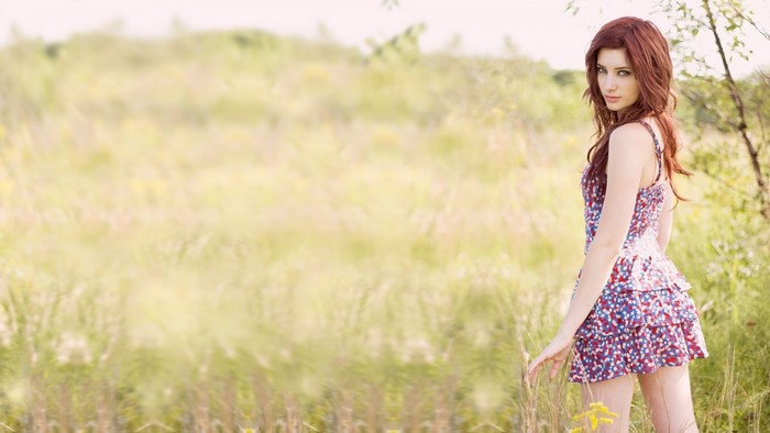 Woman in floral dress in a grassy field