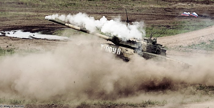 T-80 tank firing with smoke and Russian flags