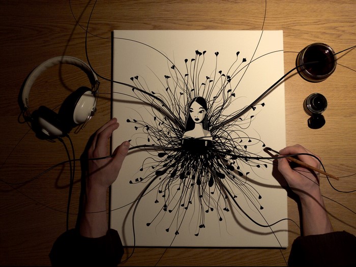 Artist painting a woman with ink and headphones