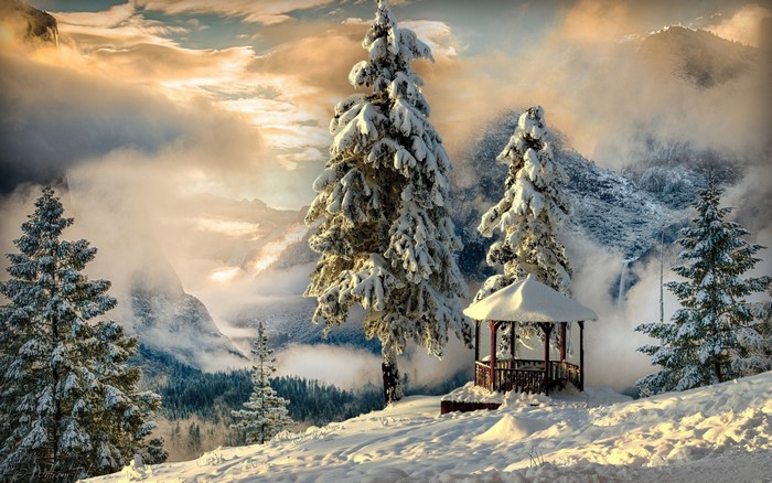 Snow-covered trees and gazebo in a mountain landscape
