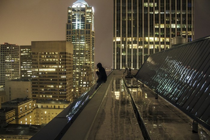 Person on a skyscraper rooftop at night