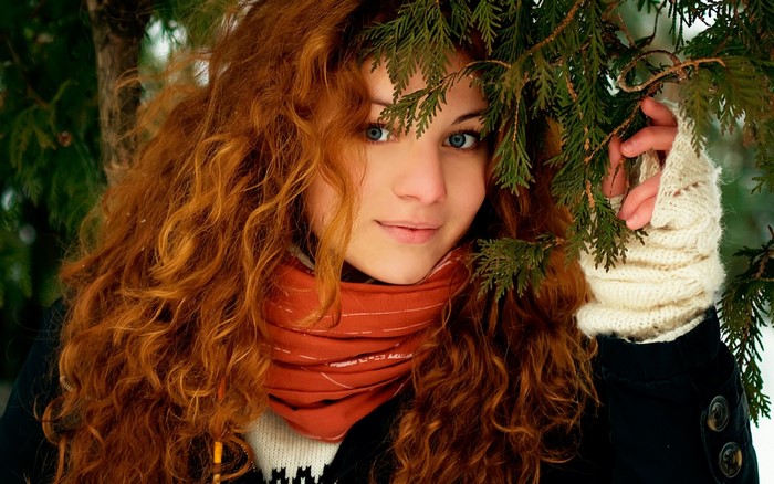 Young woman with red curly hair and blue eyes in winter