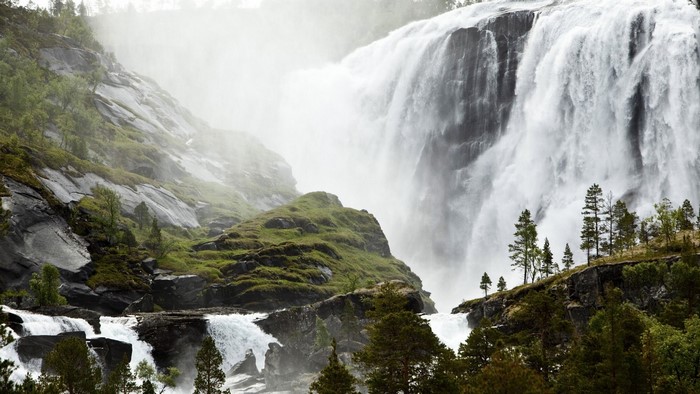 Majestic waterfall cascading down a rocky, moss-covered cliff face