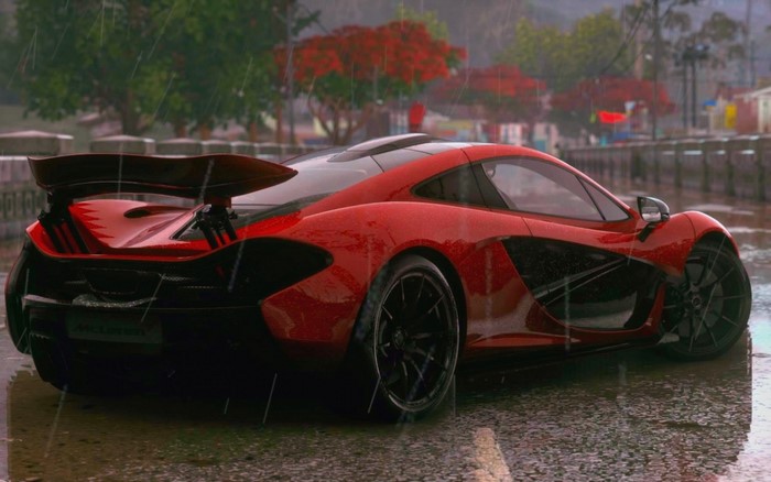 Red McLaren sports car on a wet road