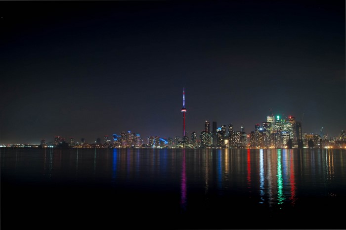 Toronto skyline at night with CN Tower and reflections