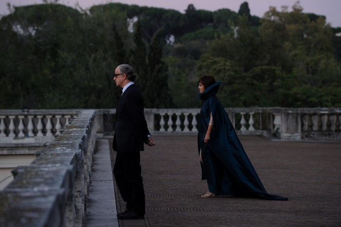 Man in suit and woman in cape on balcony