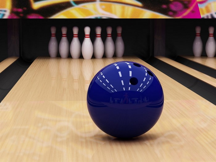 Blue bowling ball on a bowling lane with pins
