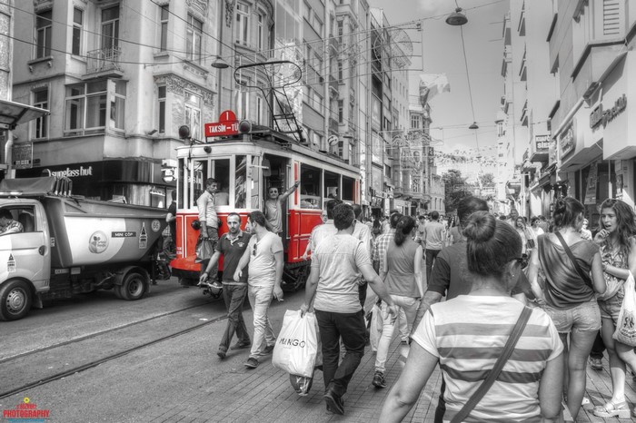 Red tram on Taksim street in Istanbul with pedestrians