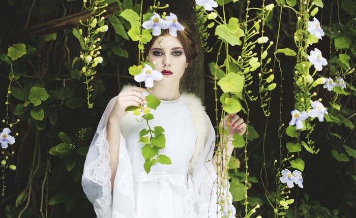 Woman in white dress with flowers in nature