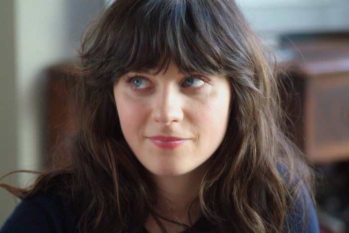 Zooey Deschanel portrait with long brown hair and blue eyes