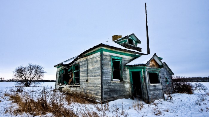 Abandoned house in a snowy rural landscape