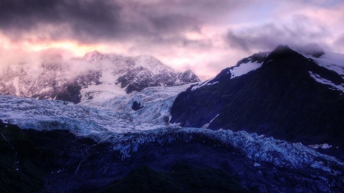 Snow-capped mountains and glacier at sunrise