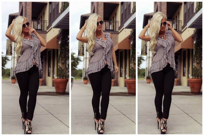 Woman in sunglasses and ruffled top posing