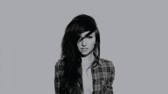 Woman with long dark hair wearing a plaid shirt