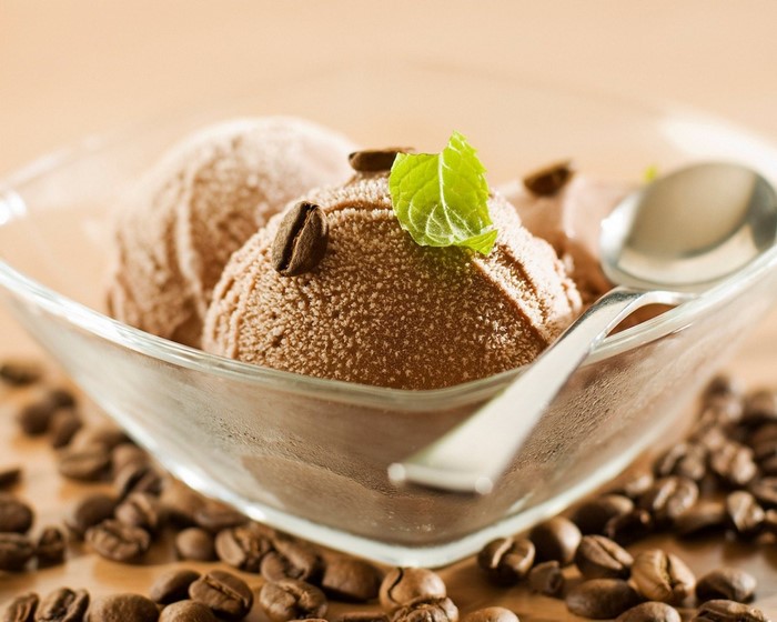 Chocolate ice cream scoops in a glass bowl with coffee beans