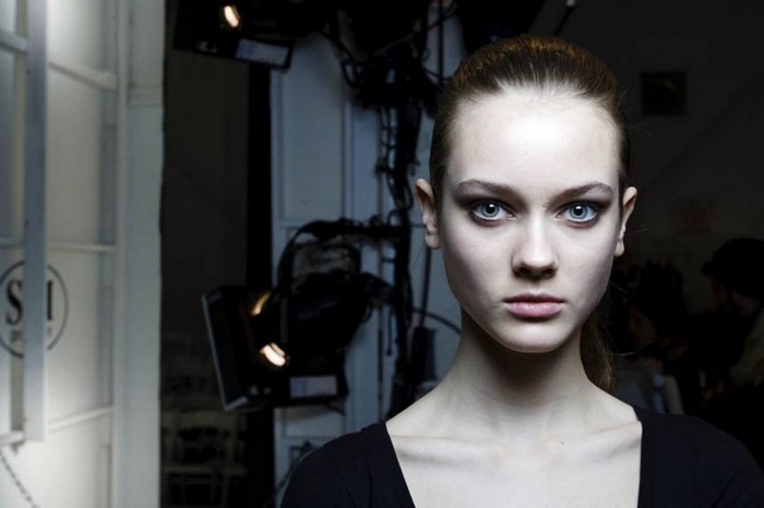 Model with dark eye makeup and ponytail