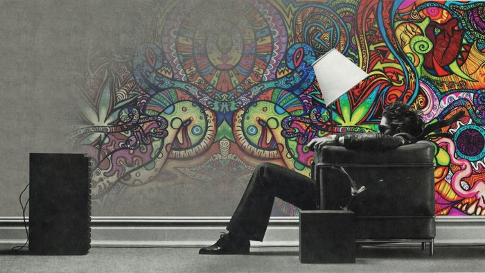 Man in chair listening to music with psychedelic mural
