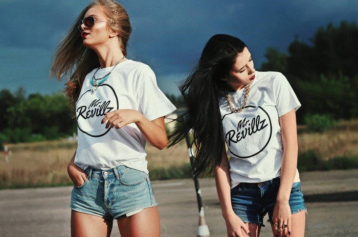 Two women wearing t-shirts and jean shorts outdoors