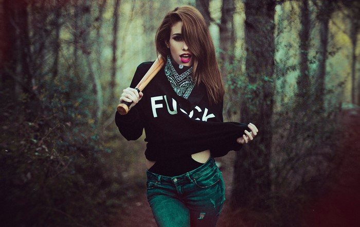 Woman with baseball bat in forest