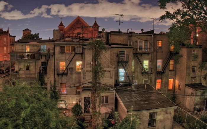 Cityscape at dusk with apartment buildings and fire escapes