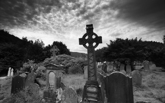 Monochrome cemetery with Celtic cross and tombstones