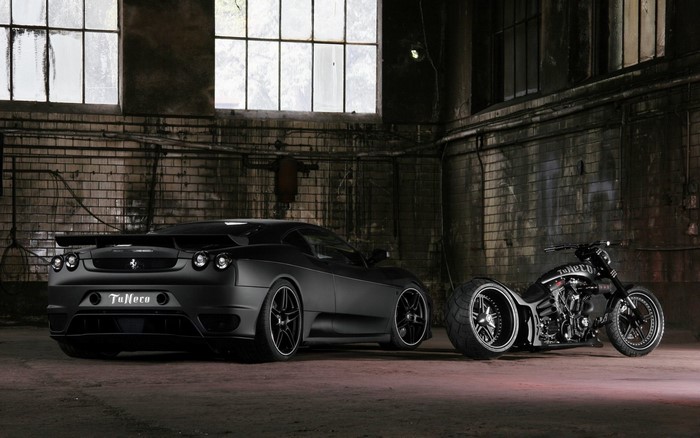 Black Ferrari F430 and custom motorcycle in garage