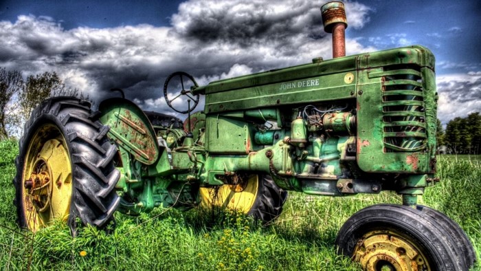 Green John Deere tractor in a grassy field