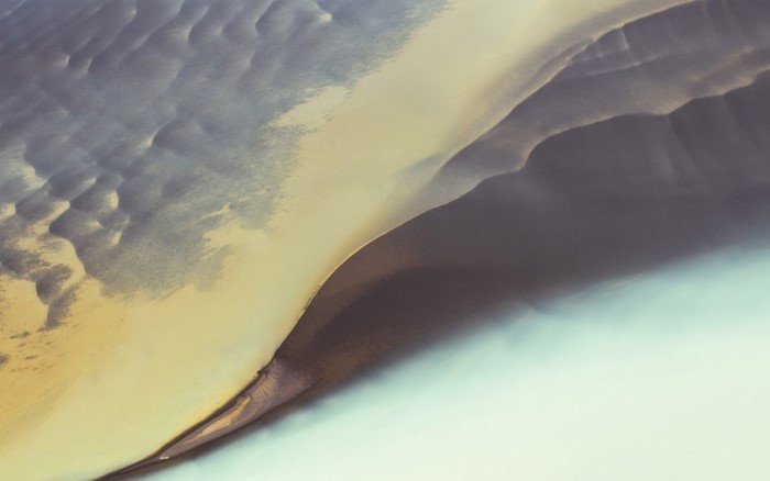 Aerial view of sand dunes and water