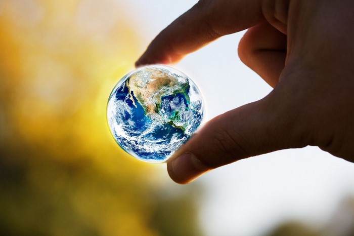 Hand holding a miniature Earth globe