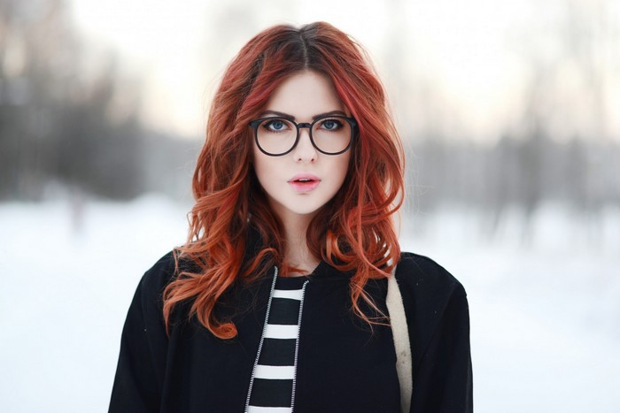 Woman with red hair and glasses in the snow