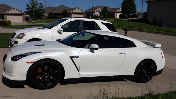 White Nissan GT-R parked next to a white SUV