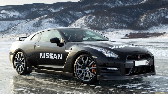 Black Nissan GT-R on a frozen lake with mountains