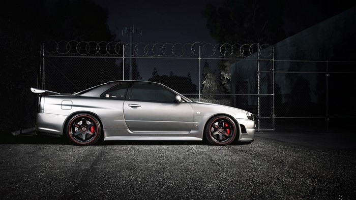 Silver Nissan Skyline GT-R R34 parked at night
