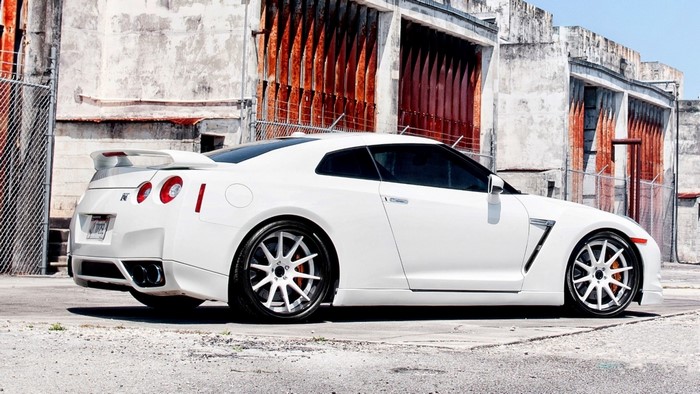 White Nissan GT-R parked near a weathered building