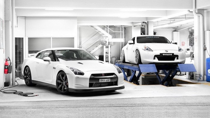 Two white Nissan sports cars in a garage